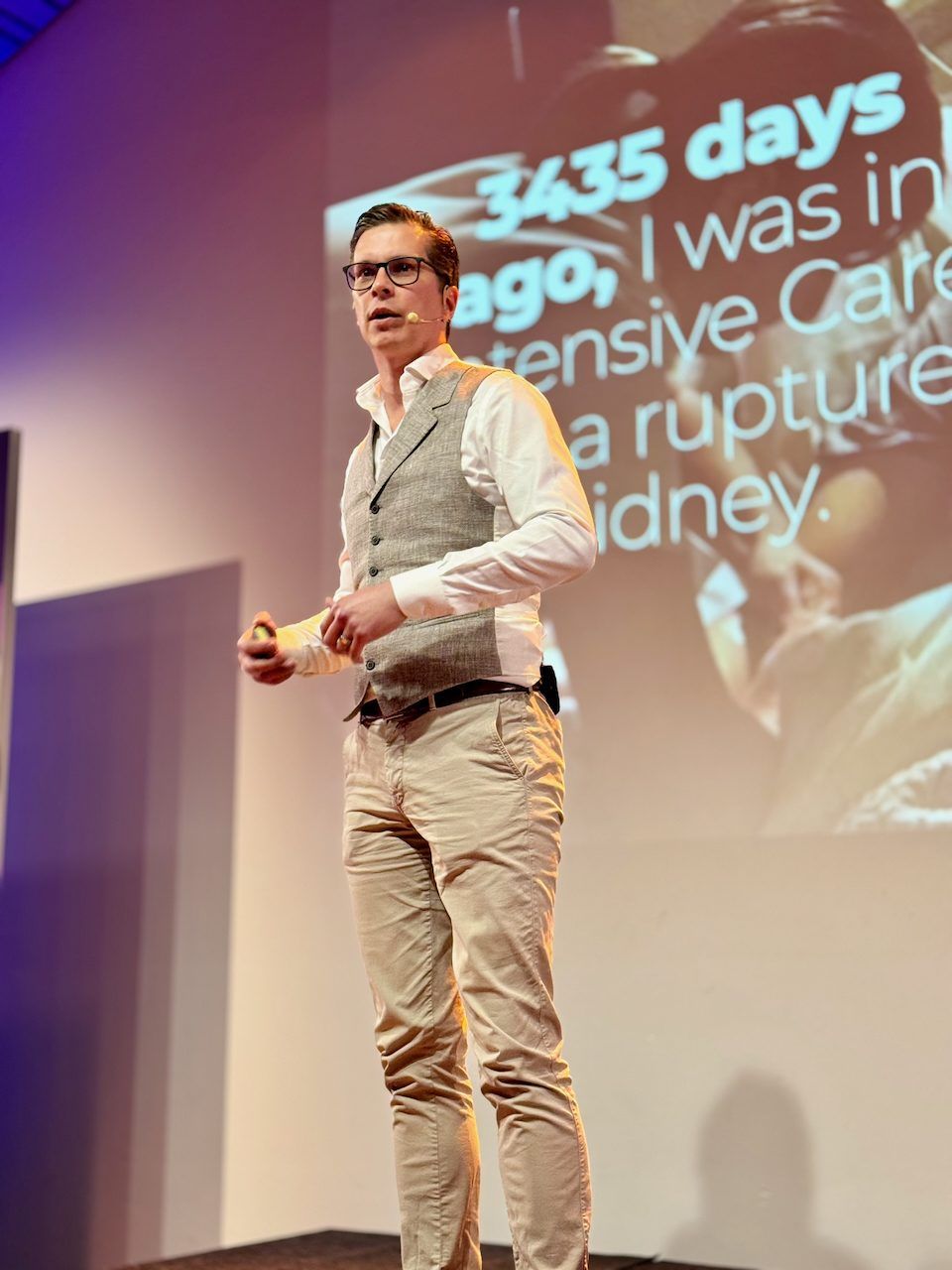 Polle on stage in front of a slide that reads: 3435 days ago, I was in intensive care with a ruptured kidney
